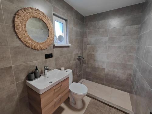 W łazience znajduje się umywalka, toaleta i lustro. w obiekcie Modern family house by the lake in Zarasai w mieście Štadviliai