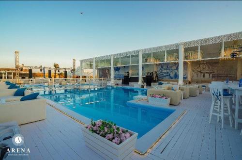 une grande piscine avec des tables et des chaises dans un bâtiment dans l'établissement selena bay resort, à Hurghada