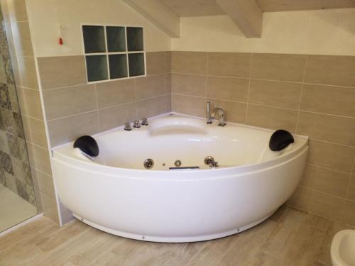 een groot wit bad in de badkamer bij La Vista del Poggio in Castellaro