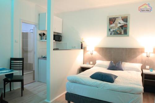 a bedroom with a bed and a desk and a table at Szín-Ház Apartman in Gyula