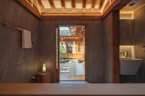 a bathroom with a door open to a yard at Luxury hanok with private bathtub - SN02 in Seoul