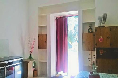 cocina con ventana con cortina roja en Villa Chorion, en Corigliano d'Otranto