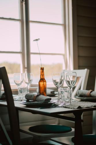 a table with wine glasses and a bottle on it at Hasselö Hostel in Hasselö