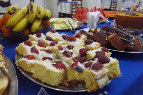 a table topped with two plates of cake and fruit at Hotel Jaú in Jaú