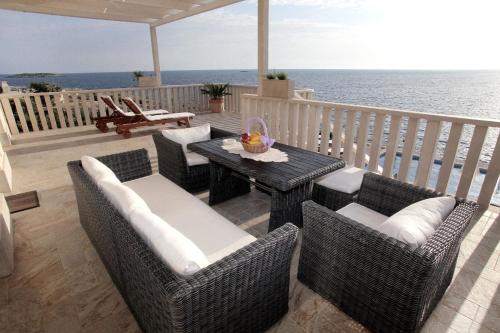 un patio con mesa, sillas y el océano en Ferienhaus mit Privatpool für 8 Personen ca 150 qm in Sevid, Dalmatien Mitteldalmatien, en Sevid