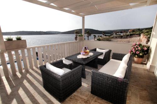 balcón con mesa, sillas y vistas al agua en Ferienhaus mit Privatpool für 8 Personen ca 150 qm in Sevid, Dalmatien Mitteldalmatien, en Sevid