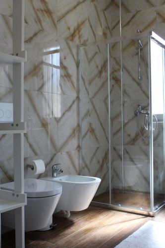 a bathroom with a shower and a tub and a sink at Vala Mar Apartament in Draç