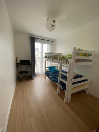 1 Schlafzimmer mit 2 Etagenbetten und einem Fenster in der Unterkunft Coucher de soleil à Pantin in Pantin