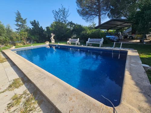 a swimming pool with blue water in a yard at Escapada Perfecta en Las Jaras in Pelayos de la Presa