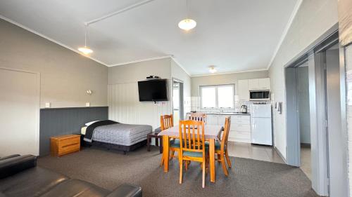 a kitchen and dining room with a table and chairs at Central Court Motel in Whangarei