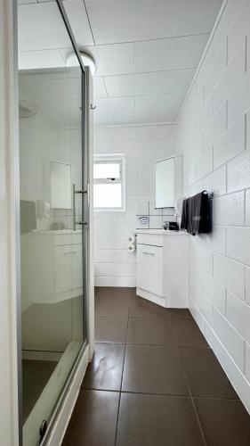 a bathroom with a shower and a sink and a counter at Central Court Motel in Whangarei