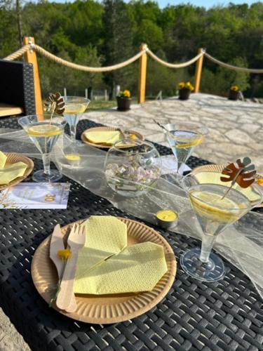 a table with glasses and plates of food on it at Jerry's Cottage Banja Luka in Banja Luka