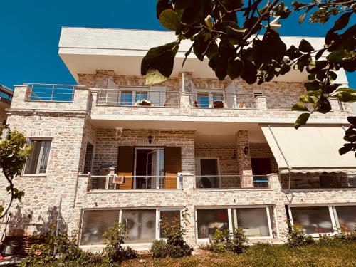 a large brick building with a balcony at Orfeu apartments Ksamil in Ksamil