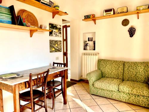 uma sala de estar com uma mesa e um sofá em Mini appartamento "Il Nido del Picchio" em Ascoli Piceno
