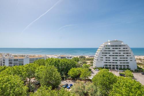 Elle offre une vue sur un bâtiment et l'océan. dans l'établissement Vue mer grandiose la Grande Motte au Lady Blue Terrasse plein ciel Parking Privé, à La Grande Motte