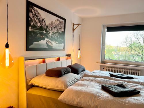 1 dormitorio con 1 cama con 2 almohadas en 2Br freeParking DUS Airp DUS Ess NTFLX, en Wuppertal