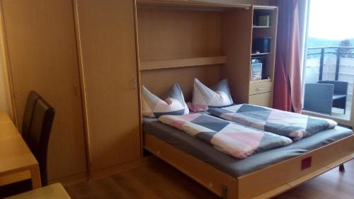 ein Schlafzimmer mit einem Bett mit Kissen darauf in der Unterkunft Ferienwohnung für 5 Personen ca 52 m in Sankt Englmar, Bayern Bayerischer Wald in Sankt Englmar