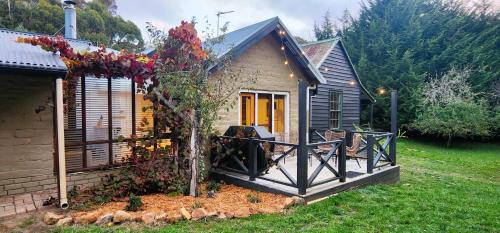 a small house with a porch with a tree at Daylesford - FROG HOLLOW ESTATE - One bedroom Homestead Villa - book for 3 nights pay for 2 - contact us for more details in Daylesford