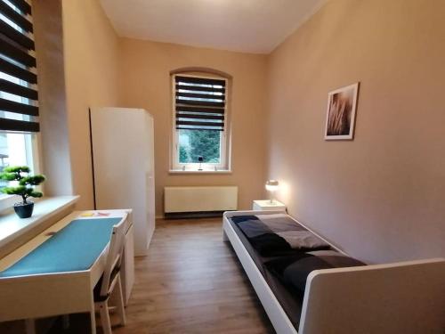 una stanza con un letto, una scrivania e una finestra di Ferienwohnung und Zimmervermietung Zur Alten Post a Claußnitz