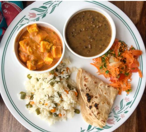 a plate of food with rice and soup and a sandwich at Hotel Grand Stay in Bhopal