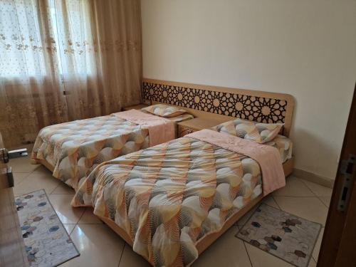 a bedroom with two beds and a window at Tom II Expresse Médical in Tunis
