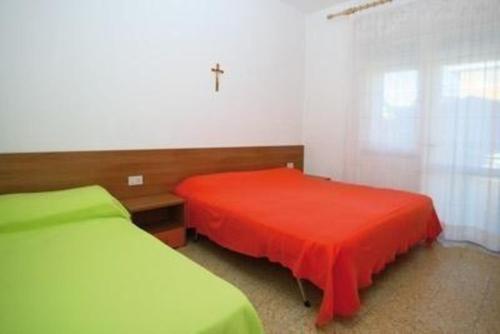 ein Schlafzimmer mit 2 Betten und einem Kreuz an der Wand in der Unterkunft Studio für 5 Personen ca 48 qm in Bibione, Adriaküste Italien Bibione und Umgebung - b59957 in Bibione