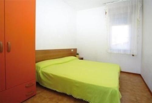 ein Schlafzimmer mit einem grünen Bett und einem Fenster in der Unterkunft Studio für 5 Personen ca 48 qm in Bibione, Adriaküste Italien Bibione und Umgebung - b59957 in Bibione