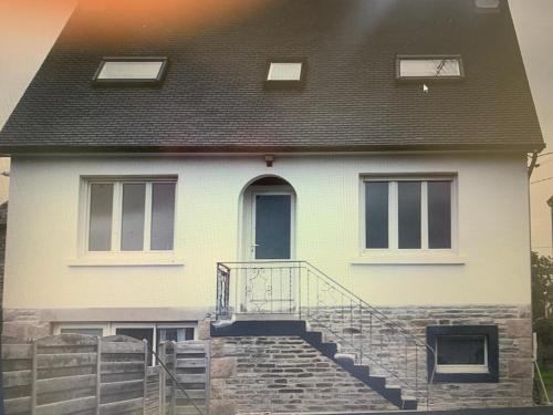 uma casa branca com um telhado preto e escadas em Ursulines em Lannion
