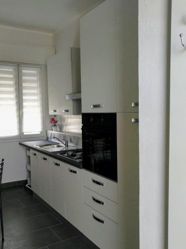 a kitchen with white cabinets and a stove top oven at La Casara appartamento Mattia in Scardovari