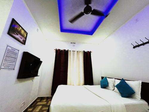 a room with two beds and a ceiling fan at Deluxe Residency in Kalpetta