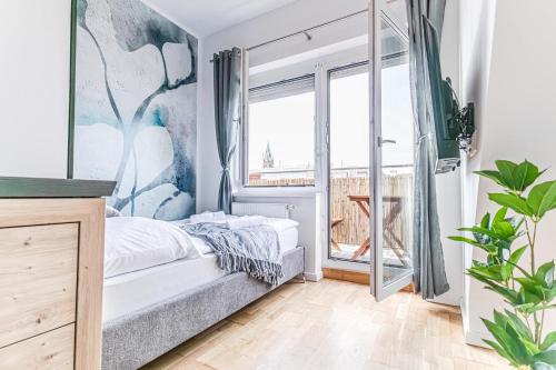 een slaapkamer met een bed en een groot raam bij 9 min to Center - Luxury Airconditioned w/ Balcony in Wenen