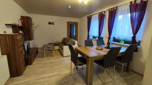 a dining room with a table and chairs in a room at Ferienwohnung Familie Schreiter in Neudorf