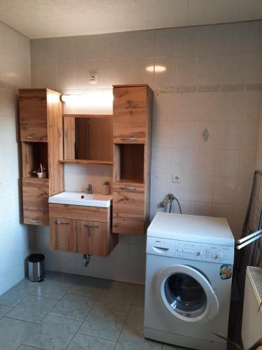 a laundry room with a washing machine and a sink at Ferienwohnung Familie Schreiter in Neudorf