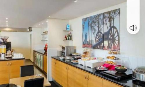 a kitchen with a counter with food on it at Lovely city apartment with private courtyard, pool, free parking, gym in Perth