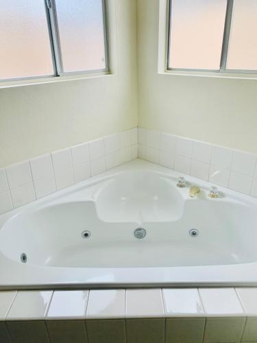 a white bath tub in a bathroom with two windows at Watercreek-Four-bedroom house in Las Vegas in Las Vegas
