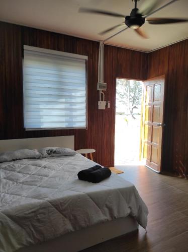 a bedroom with a bed and a ceiling fan at Chalet Bonjour in Bachok