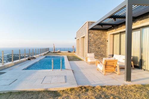 a house with a swimming pool next to the ocean at Fuga Panorama in Bodrum City