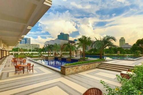 a view of the pool at a resort with tables and chairs at Torre De Manila Stunning Apartment in Manila