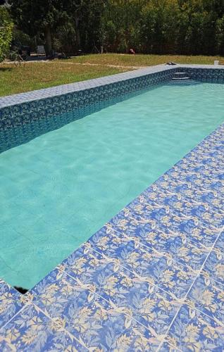 una piscina con suelo de baldosa azul y blanco en Villa le jasmin en Oulad Bou Abdallah