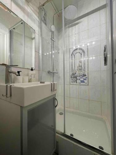 une salle de bain blanche avec un lavabo et une douche dans l'établissement Superbe Appart entier au pied de la Gare RER, à 15 min de Paris & Orly, à Juvisy-sur-Orge
