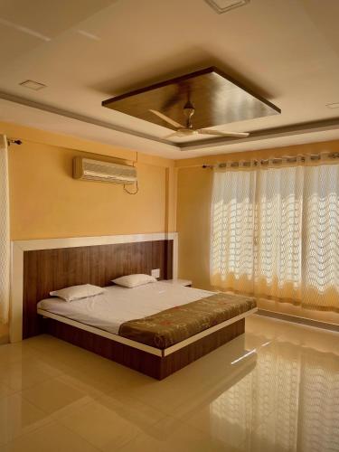 1 dormitorio con 1 cama y ventilador de techo en Hotel Island, en Kolhapur