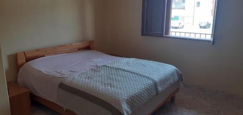 1 cama pequeña en un dormitorio con ventana en 2 chambres d’hôtes, en Tarrafal