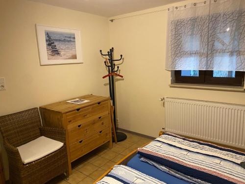 a bedroom with a bed and a dresser and a window at Rügen - Promoisel - Auszeit am Kreidesee in Sagard