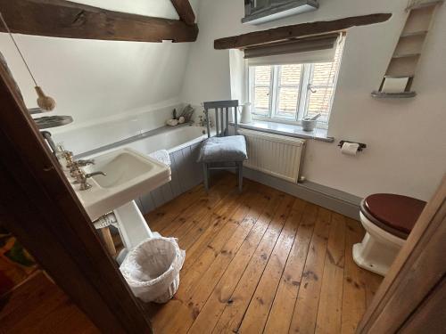 a bathroom with a sink and a toilet and a window at Cosy, historic cottage, Centre Petworth in Petworth