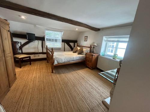 a bedroom with a bed and a tv and a window at Cosy, historic cottage, Centre Petworth in Petworth