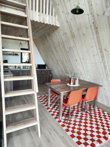 - une salle à manger avec une échelle, une table et des chaises dans l'établissement Racine lodges, à Saint-Léon-sur-Vézère