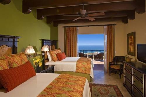 a bedroom with two beds and a view of the ocean at Incredible 3BR Ocean View Villa in Cabo San Lucas in Cabo San Lucas