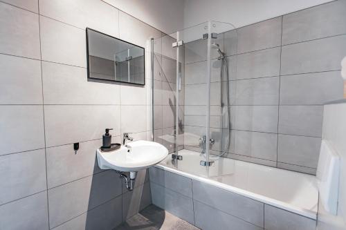 a white bathroom with a sink and a bath tub at PRIME - 2 Zimmer Wohnung direkt am Fluss in Leipzig