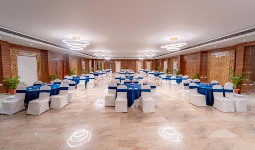 a banquet hall with blue and white tables and chairs at Playotel Resort Bhopal in Bhopal
