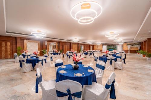 a large banquet hall with blue tables and white chairs at Playotel Resort Bhopal in Bhopal